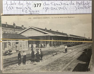 une vieille photo d'une gare où l'on voit des gens debout sur les voies
