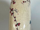 a white vase with a blue and red design on it