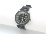 a black watch with green numbers on it on a white surface
