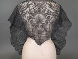 une veste en dentelle noire et blanche sur un mannequin