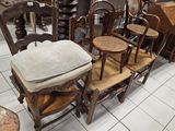 plusieurs chaises et une table dans une pièce avec beaucoup de meubles