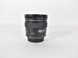 a black camera lens sitting on a white surface