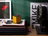 a yellow box sitting on top of a stack of books next to a camera