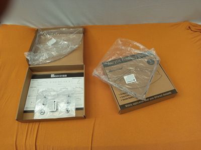 deux cartons contenant du matériel électronique posés sur un lit