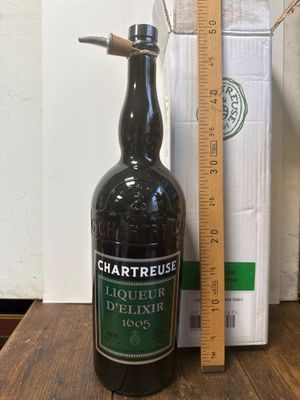 Des bouteilles d'alcool sont posées sur une table en bois à côté d'une règle.