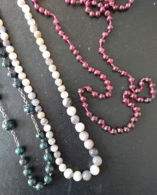 Trois colliers en perles de grenat et pierre dure