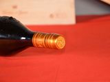 a bottle of wine sitting on a red cloth