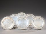 six silver plated dishes on stands on a gray surface