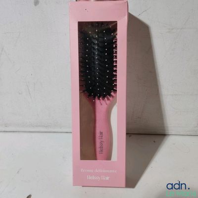 a pink brush in a pink box on a white table