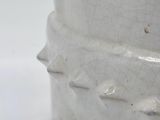 a close up of a white vase on a table