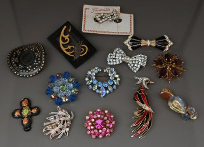 Diverses broches et boucles d'oreilles vintage sont exposées sur une table