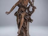 une statue en bronze représentant une femme assise sur un socle