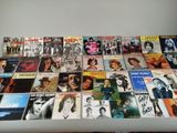une table sur laquelle sont posées de nombreuses pochettes d'albums différentes