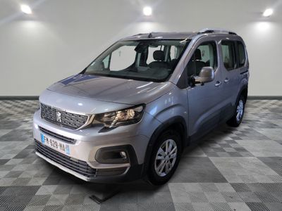 La camionnette argentée est garée sur un sol à damier dans un garage.