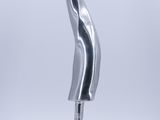 une sculpture en argent représentant une vague, posée sur un socle métallique