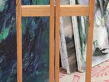 un chevalet en bois posé devant une exposition de tableaux