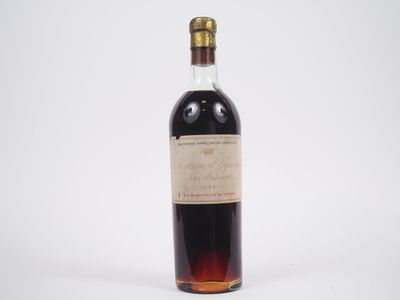 une vieille bouteille de vin posée sur une surface blanche