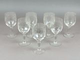 six verres à vin alignés sur une table