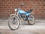 a blue and white motorcycle parked in front of a brick wall