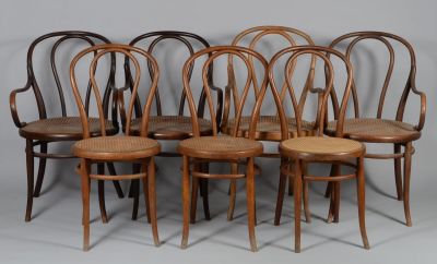 six chaises en bois sont alignées contre un mur gris