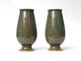 two vases that are sitting on a white surface