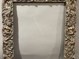 an ornate silver frame with a crown on top of it