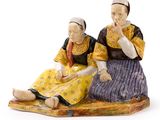 une figurine représentant deux personnes assises par terre