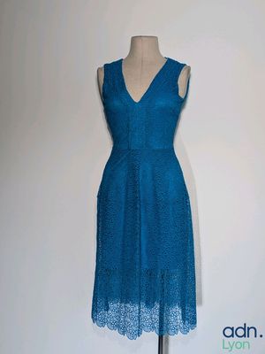 une robe bleue posée sur un mannequin, sur fond blanc