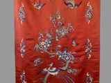 a red wall hanging with birds and flowers on it