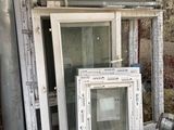 un tas de vieilles fenêtres empilées devant un immeuble