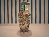 a vase that is sitting on a table in front of a striped wall