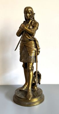 figurine en bronze représentant un homme avec un chien, posée sur une table