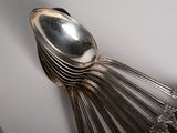 a lot of silver spoons and spoons on the table