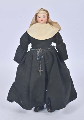an image of a doll of a woman in a black dress and a nun ' s hat