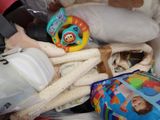 a pile of baby items in a basket with a stuffed animal