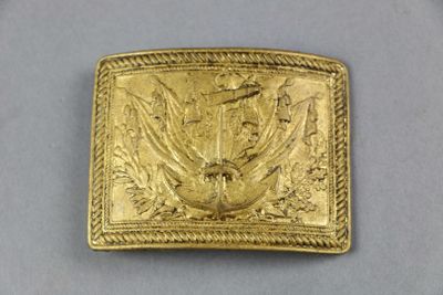 a close up of a gold belt buckle with a bird on it