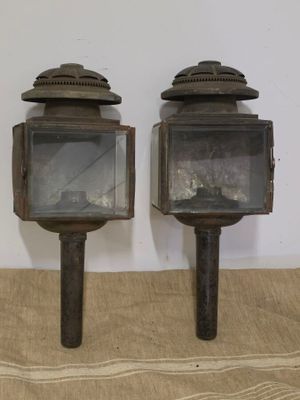 deux vieilles lanternes posées sur une nappe en burlock, sur une table
