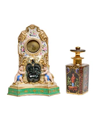 a small clock and a bottle of perfume on a white background