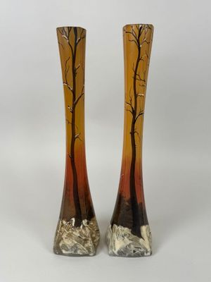 une paire de vases sur lesquels sont peints des arbres sur fond blanc