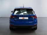 the rear of a blue car is parked in a white room