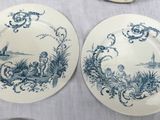 several blue and white plates on a table with a white table cloth