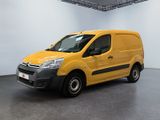 La camionnette jaune est garée dans une pièce blanche au sol noir.