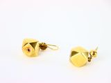 une paire de boucles d'oreilles en or sur fond blanc