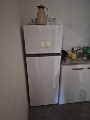 un réfrigérateur blanc dans un coin d'une petite cuisine