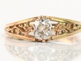 a close up of a gold ring with a diamond in it