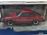 a red toy car in a box on the floor