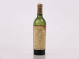 une vieille bouteille de vin posée sur une table blanche