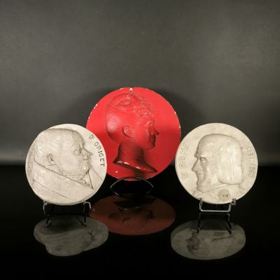 three different types of silver and red coins on a black surface