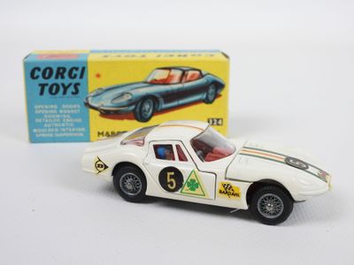 une petite voiture posée à côté d'une boîte de jouets