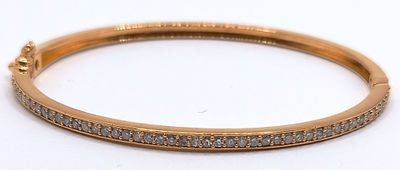 a close up of a gold bracelet with diamonds on it